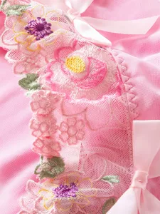 Pink mesh floral embroidery lace lingerie detail close-up showing exquisite craftsmanship.