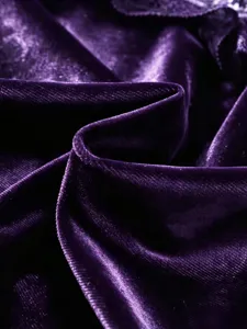 Detailaufnahme von tiefviolettem Samtstoff mit weicher Textur und edlem Glanz.