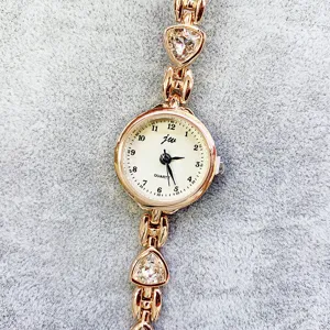 Elegante Damen Quarzarmbanduhr mit Herz Kristall Armband und goldenem Zifferblatt.