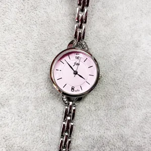 Silbernes Metallarmband Damen Quarzuhr Detailaufnahme, rosa rundes Zifferblatt mit Zahlen.