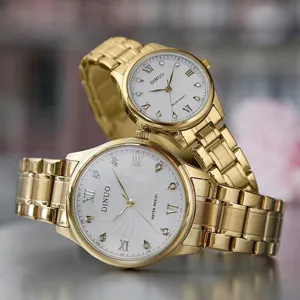 DINUO goldfarbenes Edelstahl Quarz Paar Uhr Set mit weissem Zifferblatt und Kristallen.
