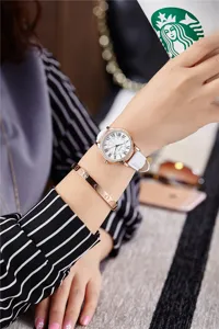 Close-up wrist detail of women rhinestone quartz watch with white leather strap and roman numerals.