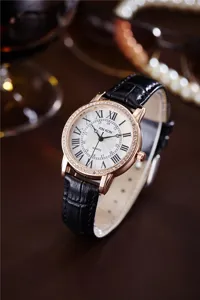 Close-up detail of women quartz watch with rhinestone bezel, Roman numerals and black leather strap.
