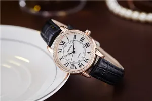 Close-up detail of women quartz watch with diamond bezel, Roman numerals and black leather strap.