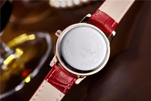 Detailed view of women's quartz watch with red leather strap and stainless steel back case.