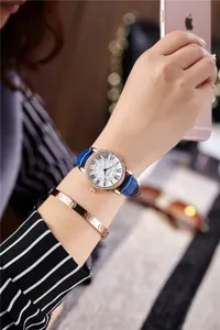 Close-up detail of a fashion women quartz watch with blue leather strap and roman numerals.