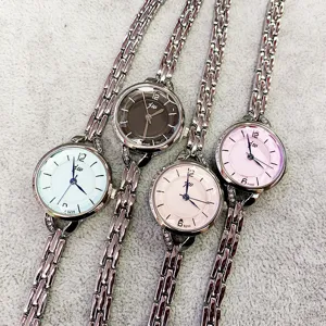 Modische Damen Quarz Armbanduhr mit schmalem Metall Kettenarmband und rundem Zifferblatt.