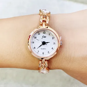 Detailaufnahme einer roségoldenen Damenquarzuhr mit Herz-Strasssteinen und weißem Zifferblatt.