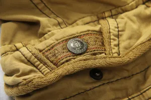 Men's casual cargo shorts detail view, featuring durable fabric and metallic button.