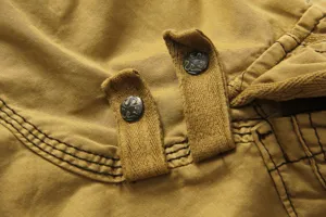 Men's casual cargo shorts detail, khaki cotton twill fabric with metal button accents.