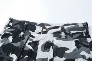 Vista detallada de pantalones cortos cargo de camuflaje para hombre con tela y bolsillos.