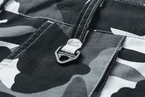 Detalle de bermudas cargo de hombre en primer plano, tela camuflaje ripstop y costuras.