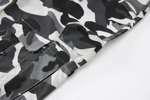 Close-up detail of men's camo cargo shorts showing pocket stitching and grid fabric texture.