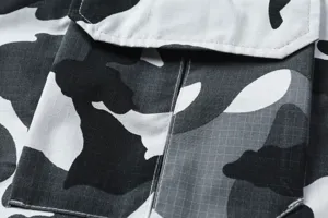 Detalle de primeros planos de shorts cargo de camuflaje para hombre con tela ripstop y bolsillos.