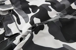 Close-up detail of mens black and white camo cargo shorts fabric and pocket stitching.