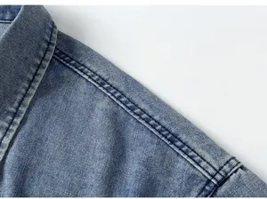 Détail de veste en jean homme montrant les coutures des épaules et le tissu bleu lavé.