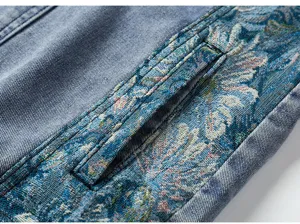 Gros-plan de la poche de veste en jean pour homme avec détails de broderie ethnique.