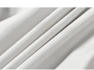 Nahaufnahme des glatten weißen Stoffes mit feiner Textur und eleganten weichen Falten.