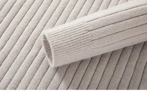 Primo piano dettagliato della texture della manica del maglione di lana a coste, grigio.