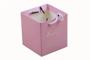Pink square paper gift bag candy box with white handles and sweet love text print.
