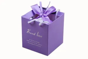 Purple square paper gift box with ribbon bow handle, elegant candy packaging bag for events.