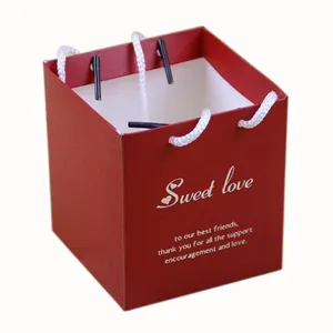 Red square gift bag with white handles, perfect for wedding candy packaging and party favors.