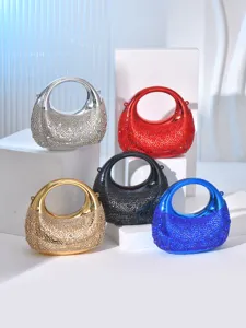 Close-up detail of luxury rhinestone evening handbags, metallic moon design with sparkling crystals.