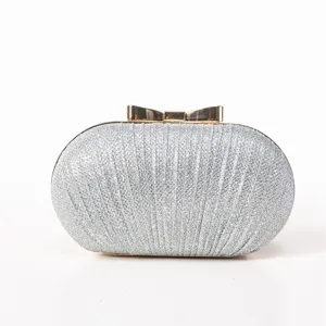 Silver glitter evening clutch detail, showcasing the sparkling texture and gold bow.
