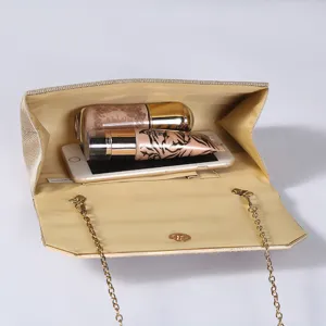 Gold glitter clutch bag interior detail showing spacious capacity for phone and cosmetics.