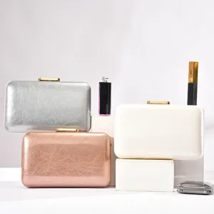 Detailed view of elegant metallic evening clutches in silver, rose gold, and white displayed.
