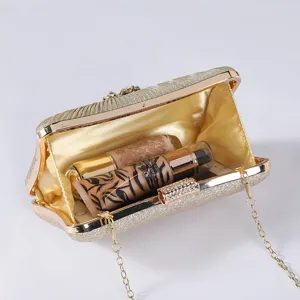Gold glitter evening clutch bag detail showing interior capacity and stylish chain strap design.
