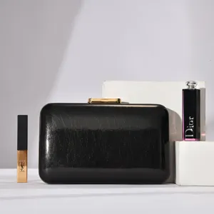 Minimalist black evening clutch bag with gold clasp, elegant design for party and wedding.