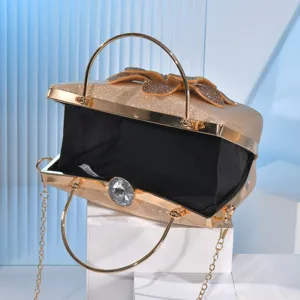 Elegant gold glitter evening clutch bag with crystal clasp, rhinestone bow and chain strap.