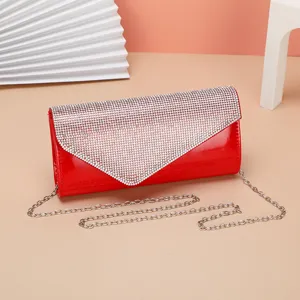 Close-up of red patent leather evening bag with shimmering rhinestones and chain strap.