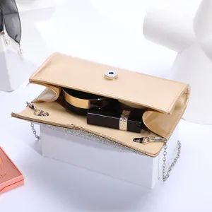 Chic champagne patent leather evening clutch bag with sparkling rhinestone trim and chain strap.