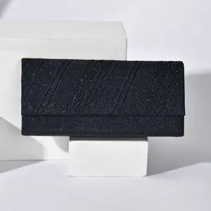 Detailed view of dark glitter evening clutch bag with chic diagonal textured pattern and flap.