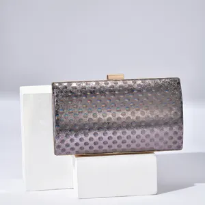 Detailed view of the elegant women's evening clutch bag with holographic polka dots and lock.