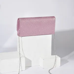 Pink glitter evening clutch bag detail view, showing sparkling texture and silver chain strap.