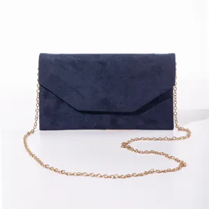 Dettaglio di pochette da sera in camoscio glitter blu scuro con catena dorata e patta a Busta.