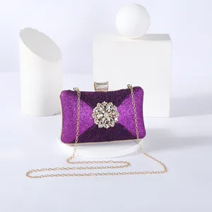 Exquisite purple glitter evening clutch bag with sparkling crystal flower detail and chain.