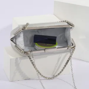 Detail shot of silver rhinestone evening clutch bag interior, showcasing refined lining and chain.