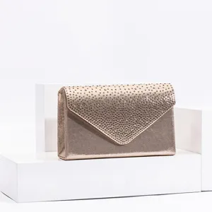 Gold evening clutch detail shot, rhinestone embellished envelope flap design, premium accessory.
