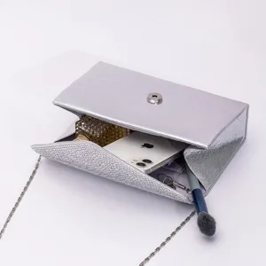 Detailed view of a silver evening clutch bag with sparkling rhinestones and practical inner space.