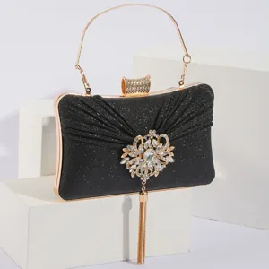 Détail pochette de soirée paillettes noires, broche tournesol strass et poignée dorée.