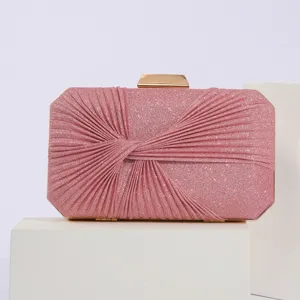 Pink glitter evening clutch bag detail shot, featuring pleated design and gold metal clasp.