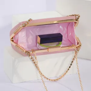 Detail view of pink PU evening clutch bag, open interior with chain strap and rhinestones.