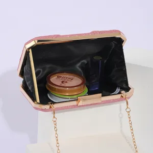 Detailed view of pink glitter evening clutch bag with gold metal frame and chain strap.