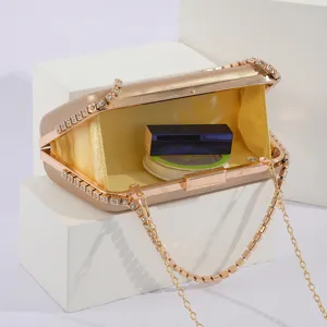 Elegant evening clutch bag with rhinestone chain detail, detailed view showing interior capacity.