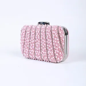 Pink pearl embellished evening clutch bag with sparkling rhinestone lines and metal clasp hardware.
