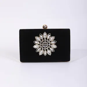 Black velvet evening clutch bag with sparkling rhinestone flower and gold frame for dress.